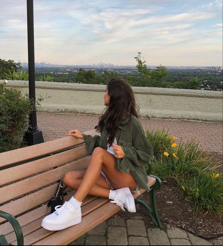 a woman sitting on top of a wooden bench