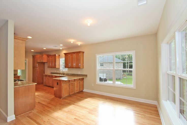 an empty kitchen and living room with hardwood floors