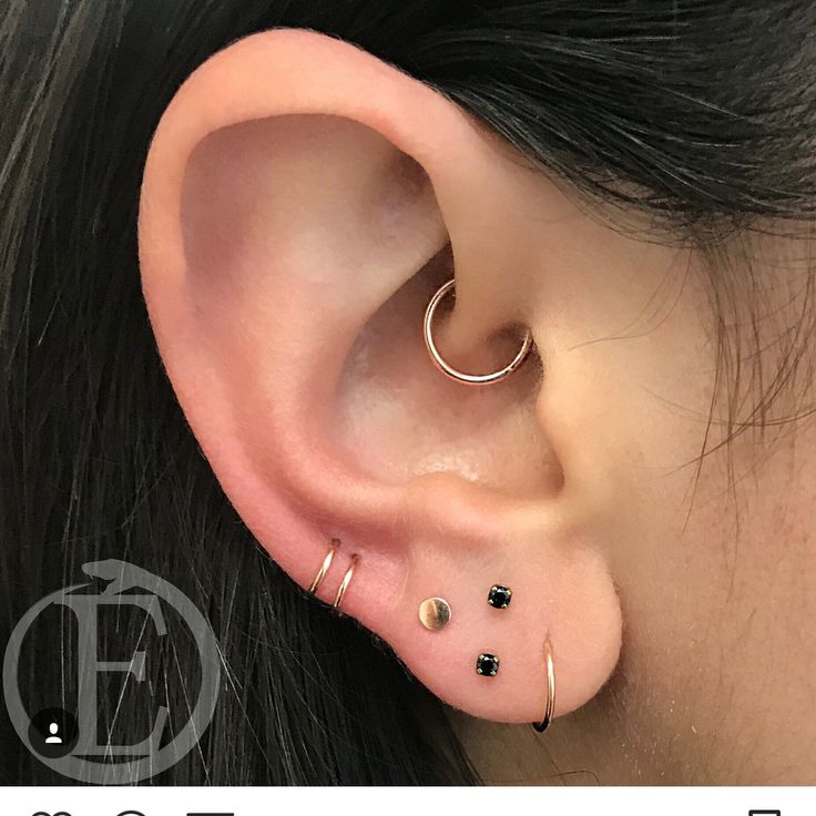 a close up of a person's ear with three different piercings on it