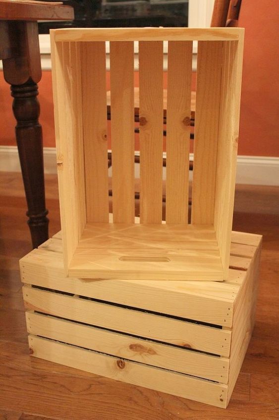 a wooden crate sitting on top of a hard wood floor next to a table and chair