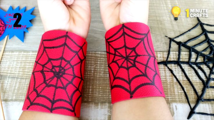 two hands with spider webs on them, one is red and the other is black