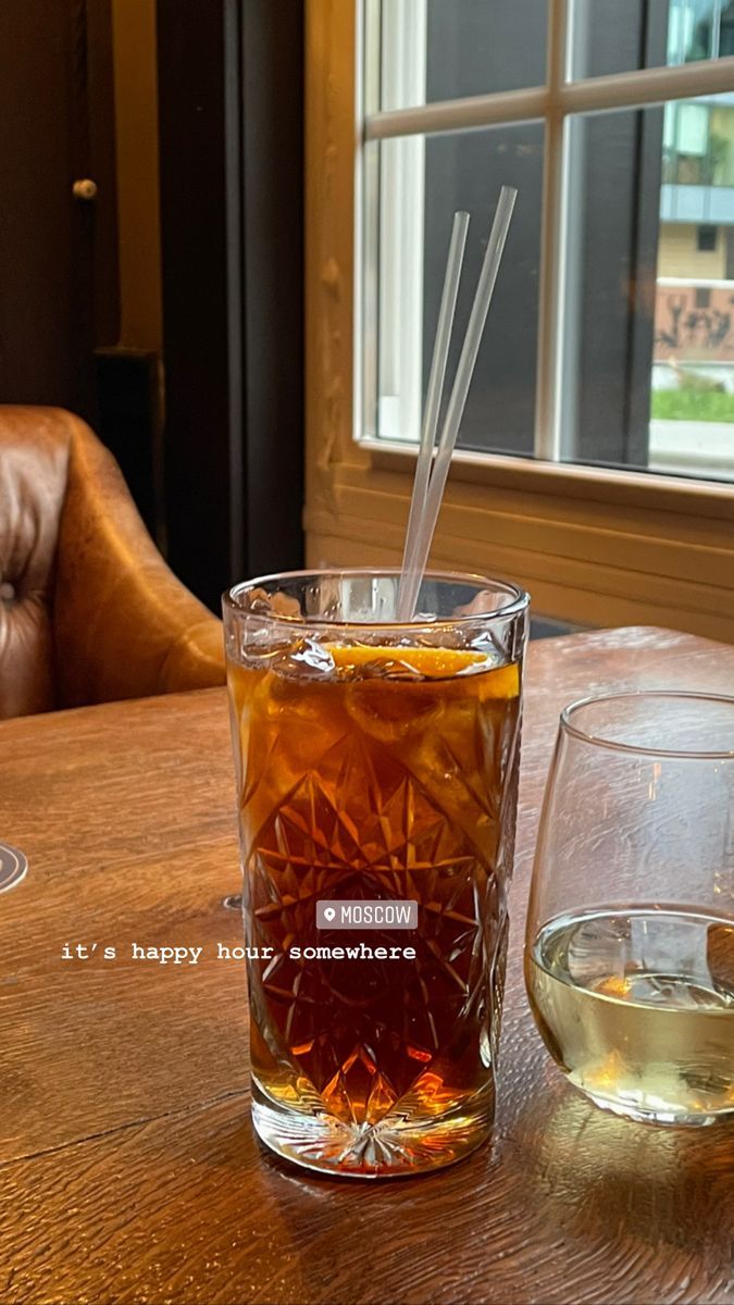 there is a glass with some liquid in it on the table next to another glass