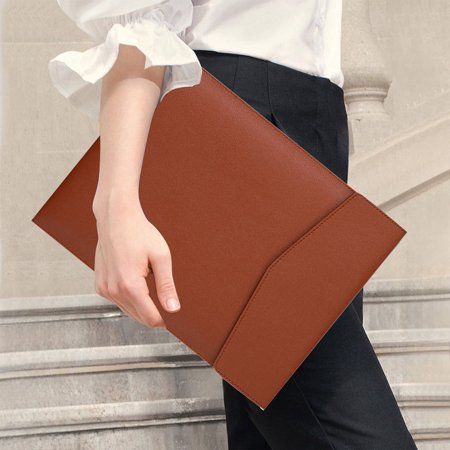 a woman carrying a brown leather clutch bag