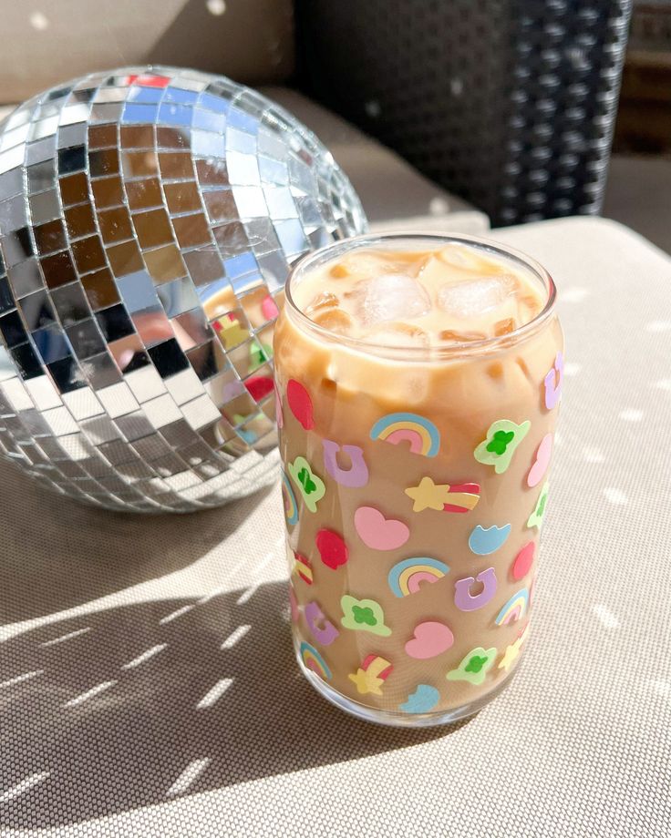 a drink sitting on top of a table next to a disco ball