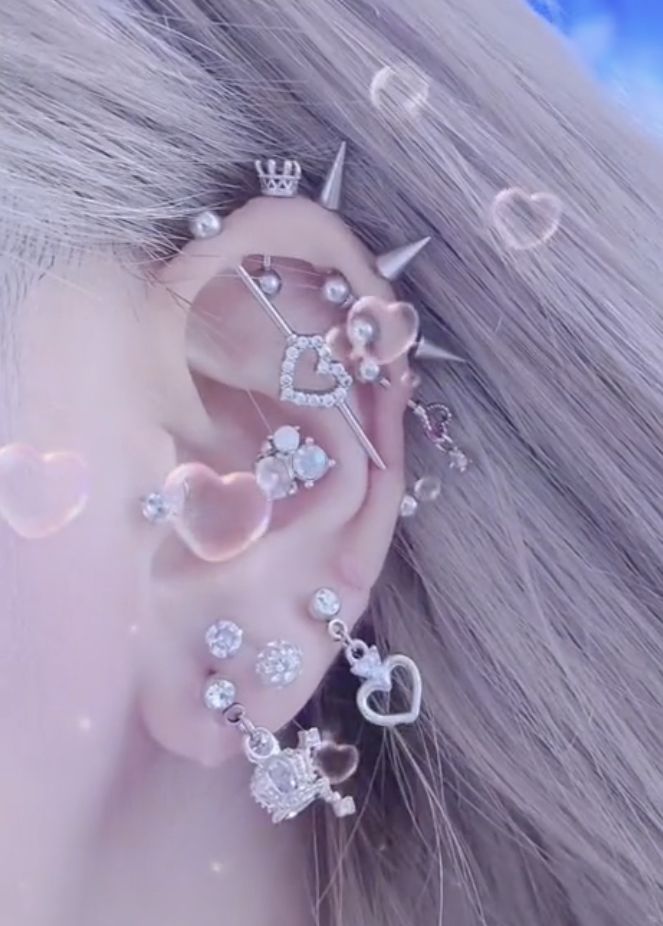 a close up of a person's ear with some piercings on top of it