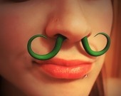 a woman with green fake moustaches on her face