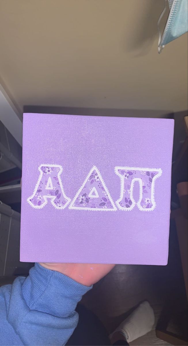 someone is holding up a purple piece of paper with the letters aja on it