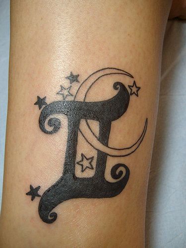 a tattoo on the leg of a woman with stars and a letter f in it