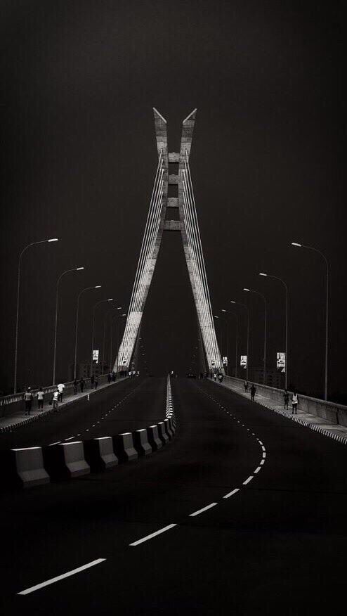 a black and white photo of a bridge at night