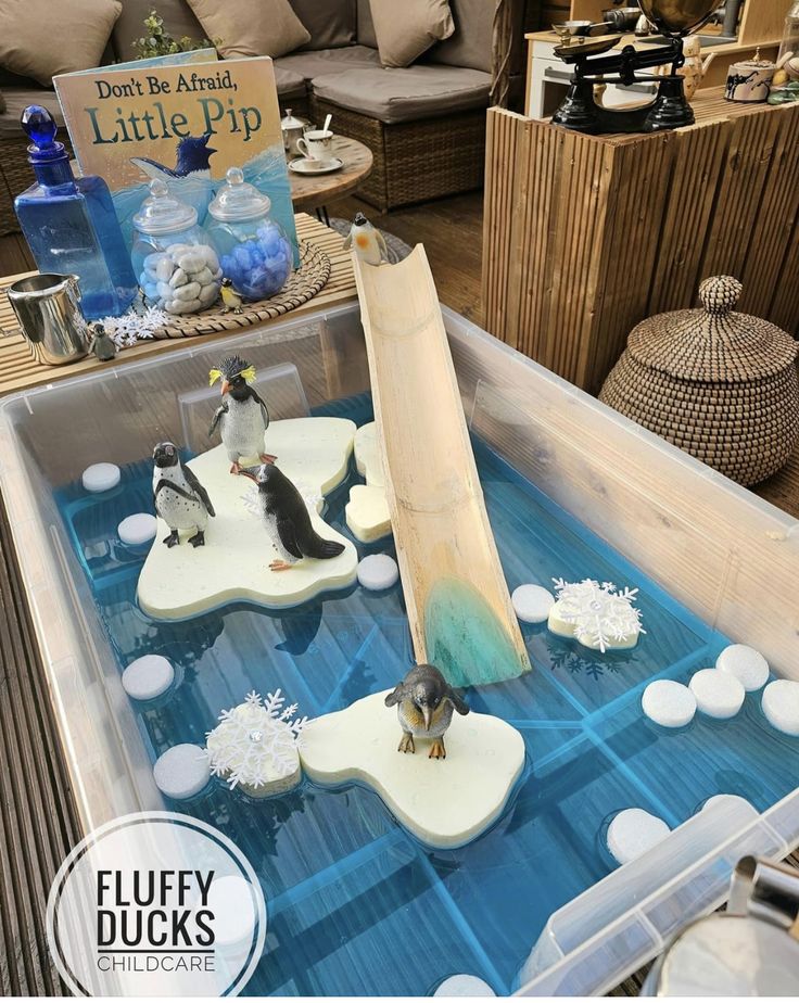 a display case filled with penguins and snow flakes on top of an ice tray