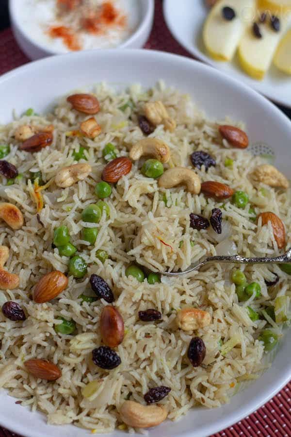 a white bowl filled with rice and nuts