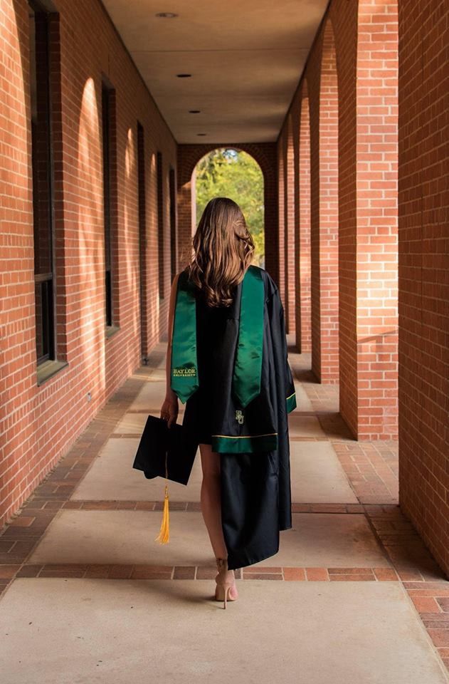 a woman is walking down the sidewalk with her hand in her pocket