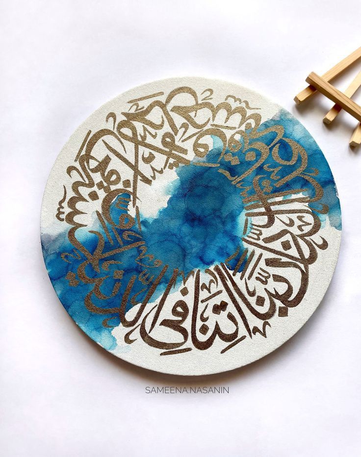 an arabic calligraphy is painted on a white plate with blue and gold inks