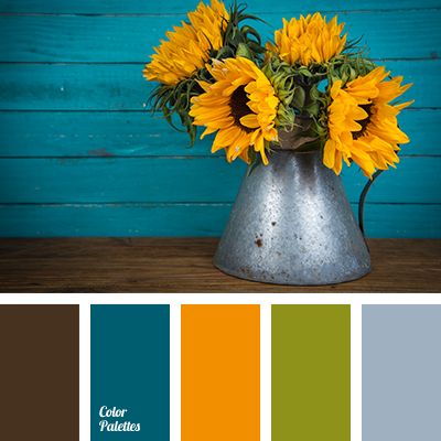 a vase filled with yellow sunflowers sitting on top of a table next to a blue wall