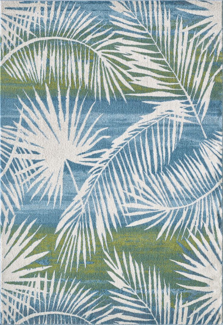 a blue and green rug with palm leaves on it