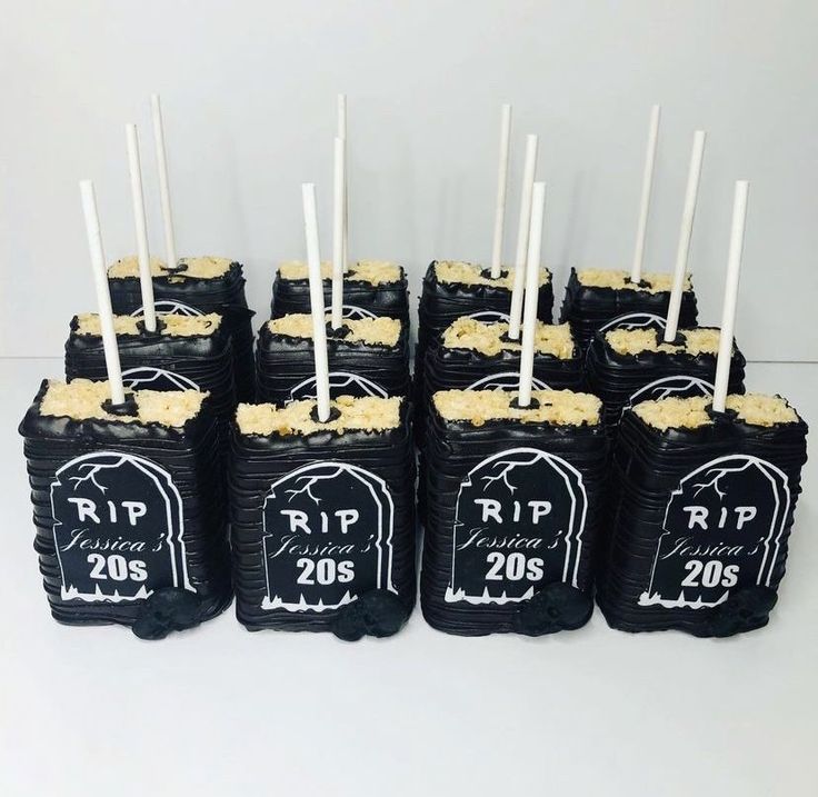 there are many black and white cakes that have candles in the shape of tombstones