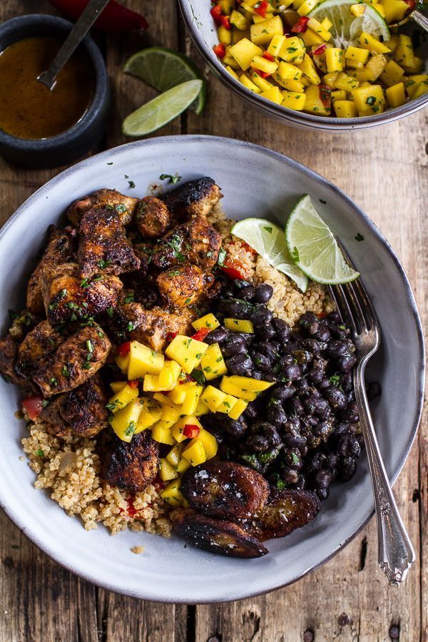 a plate with rice, black beans and mango salsa next to a bowl of chicken