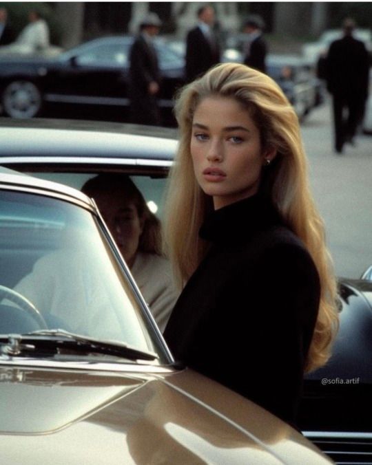 a woman standing next to a parked car