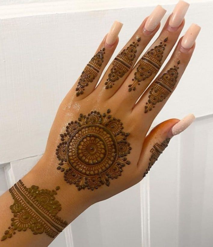 a woman's hand with henna tattoos on it