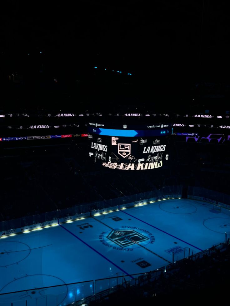 an empty hockey rink at night with lights on