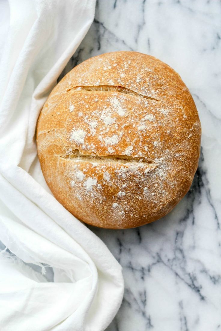 a loaf of bread sitting on top of a marble countertop next to a white towel