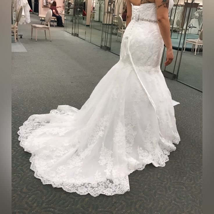 a woman in a wedding dress is looking at herself in the mirror