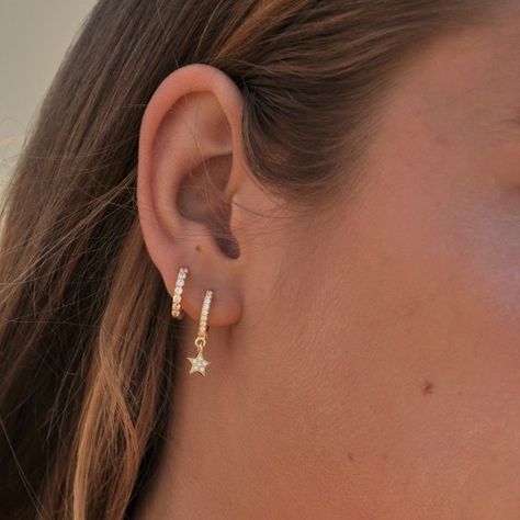 a close up of a woman's ear with two small stars on the side