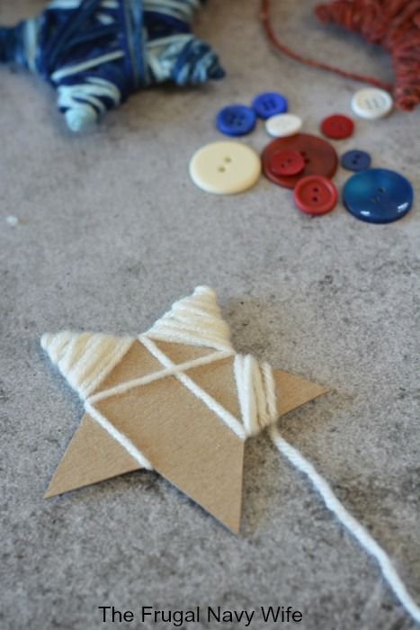 a close up of a kite on the ground with buttons and yarn in the background