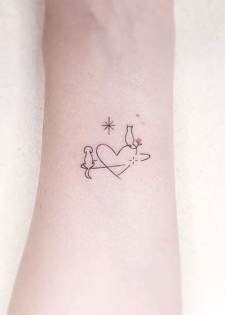 a small tattoo on the wrist of a woman with a cat and bird in it