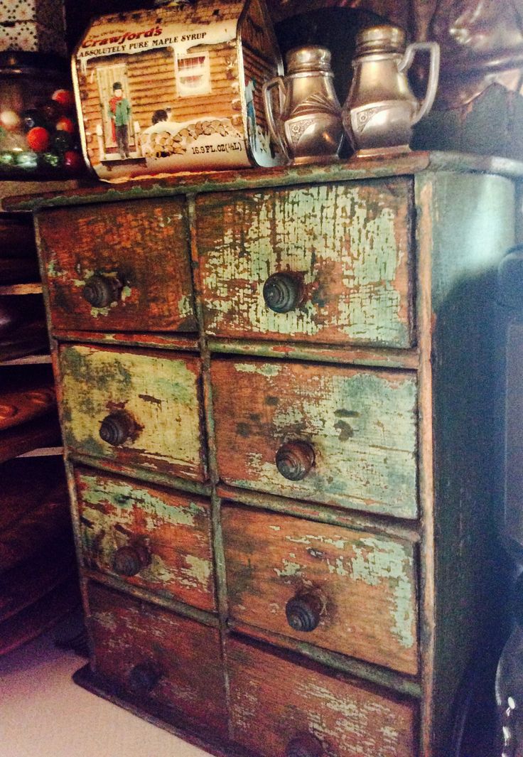 an old wooden dresser with many drawers and metal containers on it's top shelf