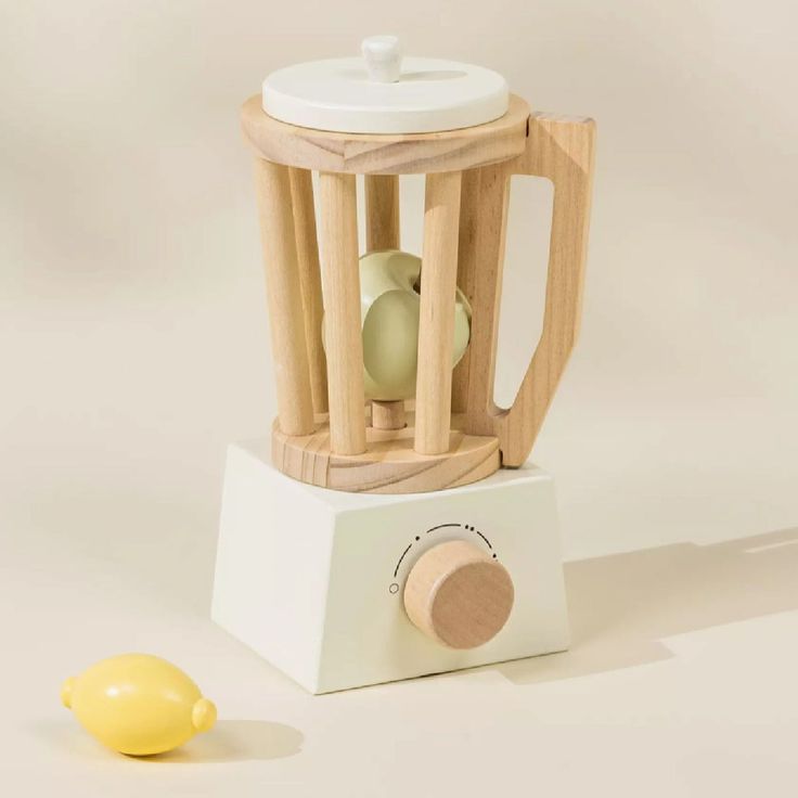 a small yellow object sitting on top of a white counter next to a wooden stand