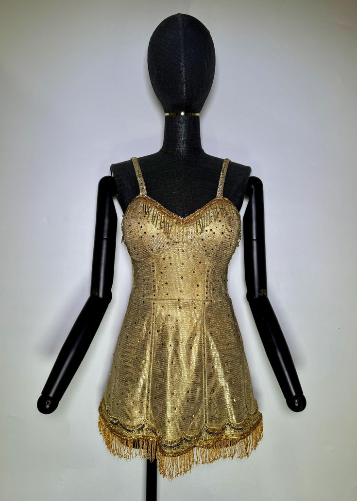 a mannequin wearing a gold dress with fringes