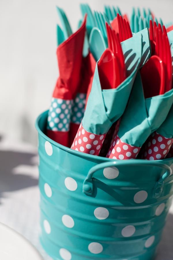 there are many forks and spoons in the blue pail with polka dots on it