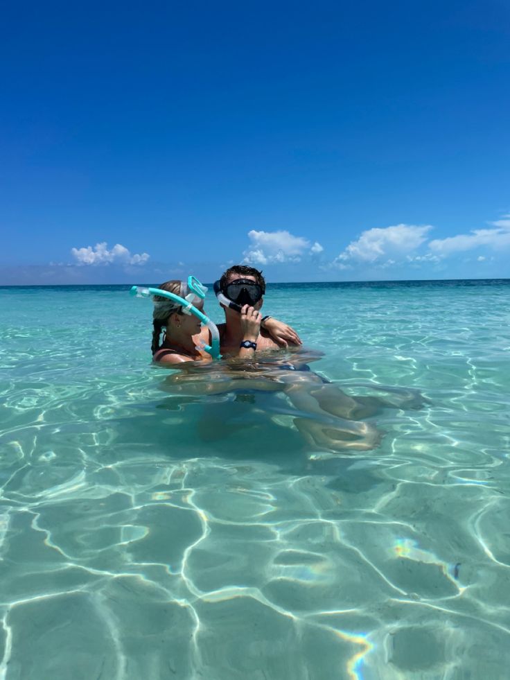 a person in the water with a mask and snorkels on their head