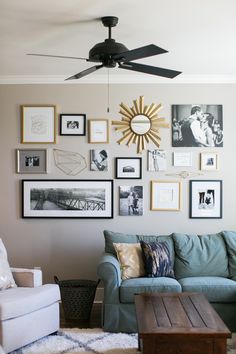 a living room filled with lots of framed pictures on the wall next to a couch