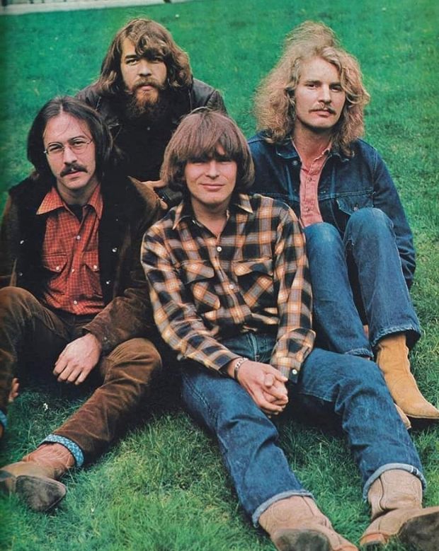 the bee gees are sitting on the grass