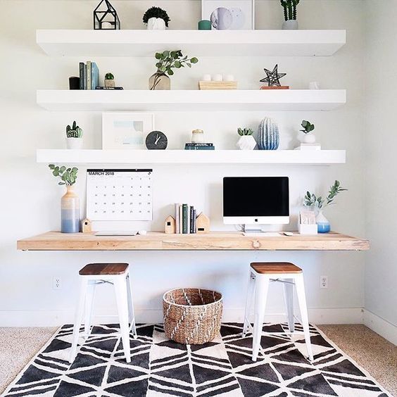 a desk with two stools in front of it and some shelves on the wall