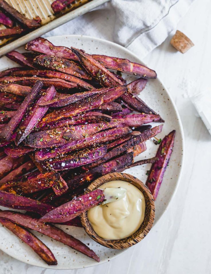 purple sweet potato wedges on a plate with dipping sauce