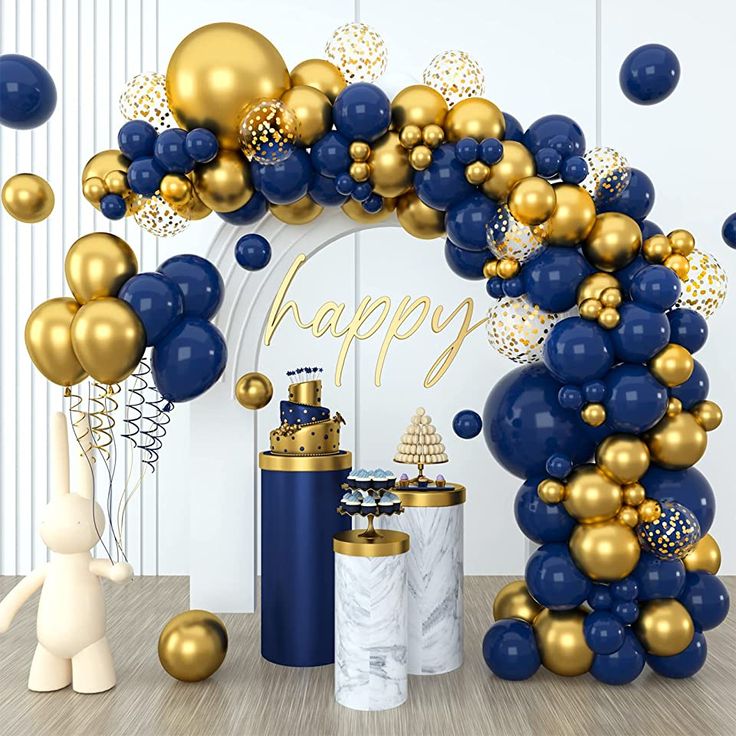 blue and gold balloon arch with happy new year balloons in the air, gift wrapped present under it