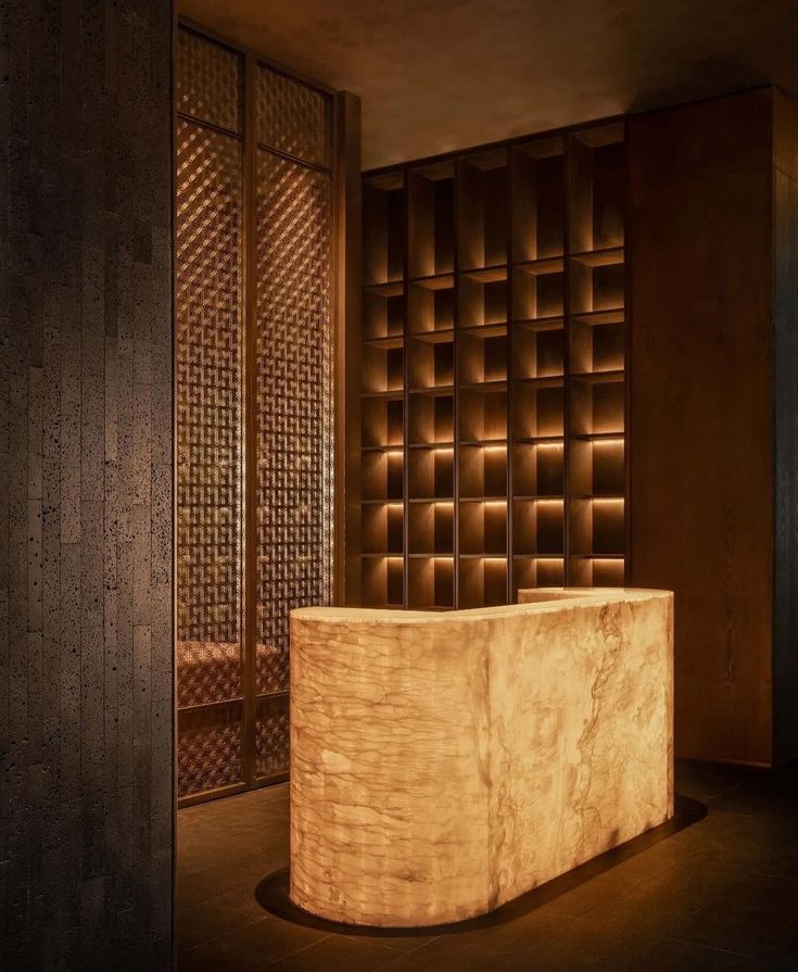 a wooden counter sitting in the middle of a room next to a wall with carved panels on it