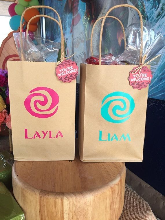 two brown bags with pink and blue logos on them sitting on top of a wooden stand