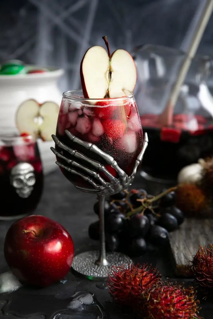 a glass filled with liquid and fruit on top of a table