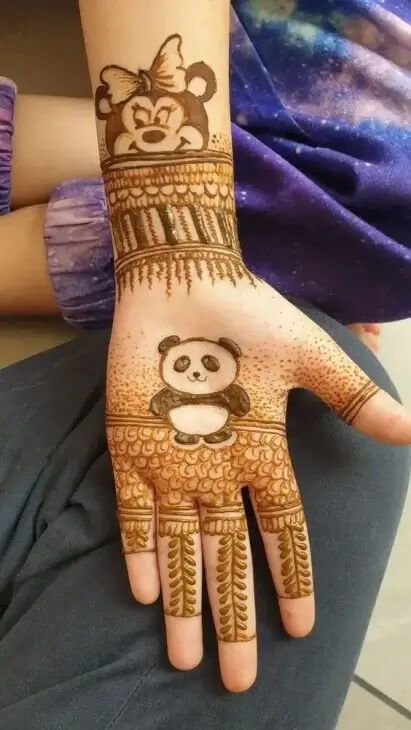 a woman's hand decorated with henna and a panda bear on the palm