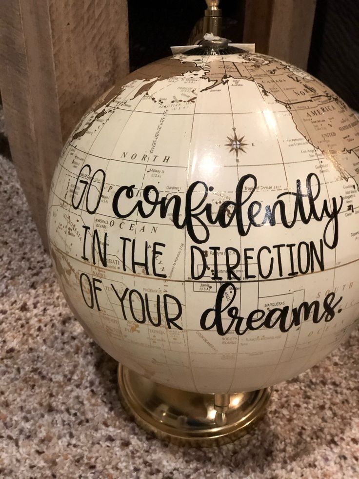 a white globe with writing on it sitting on a counter next to a wooden door