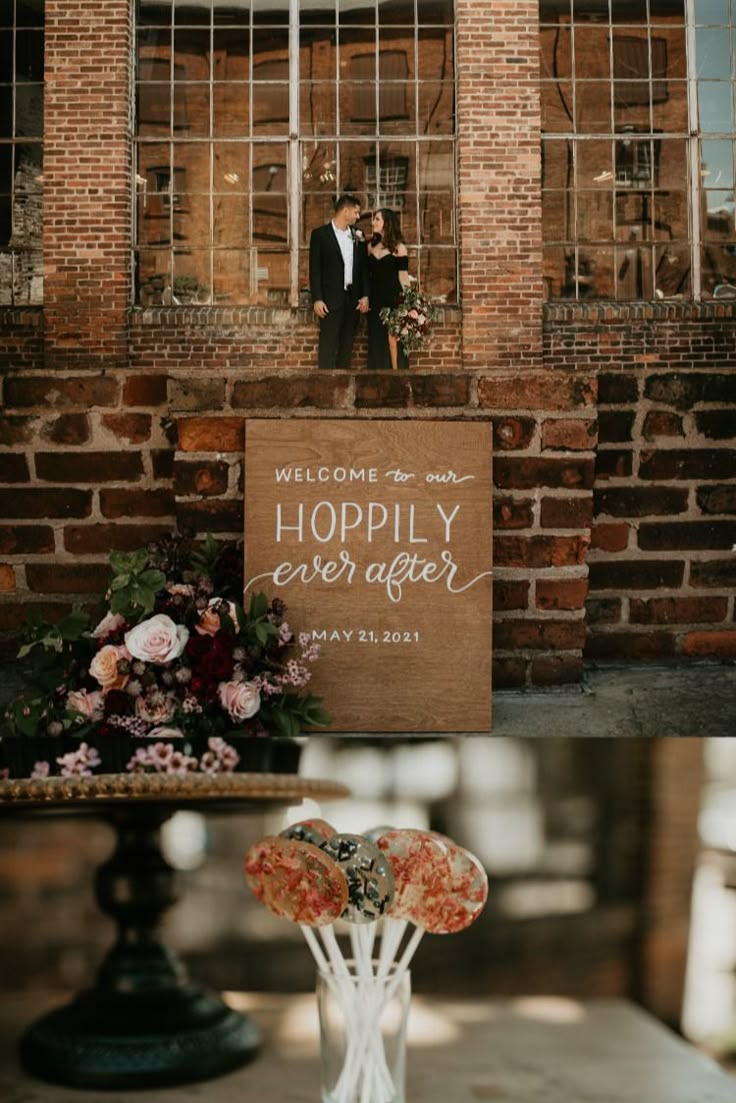 a couple standing next to each other in front of a brick building with a sign that says happily ever after