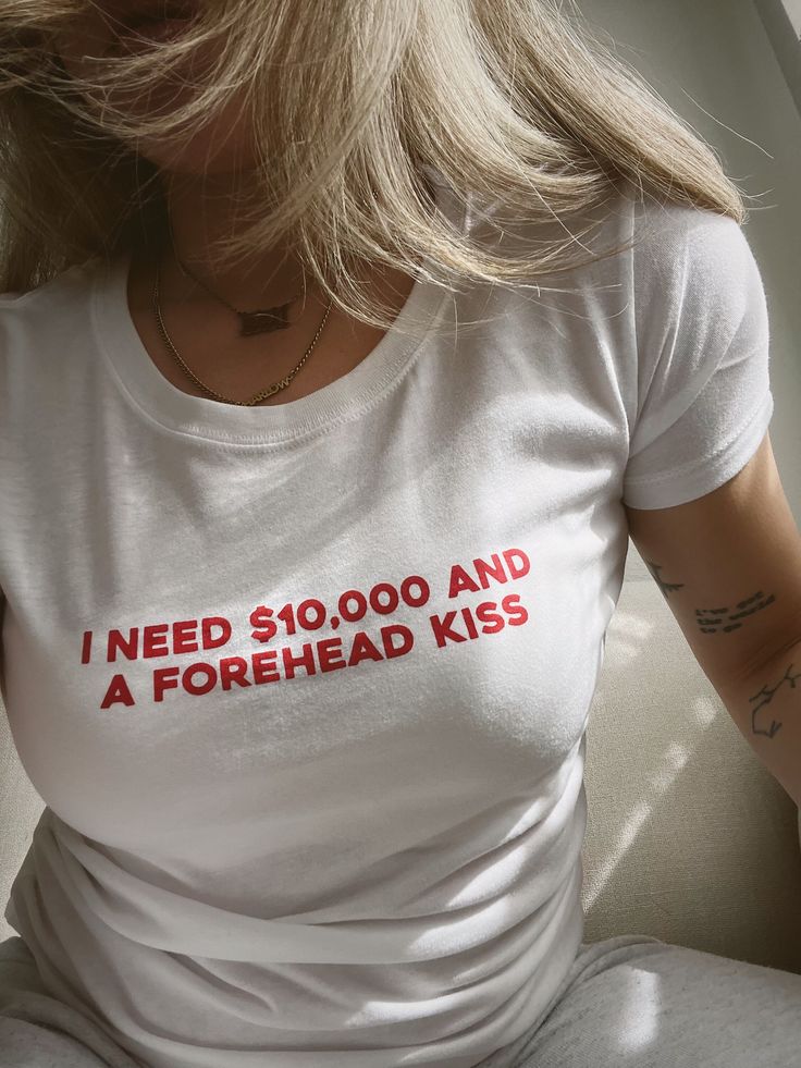 i think we all just need 10k and a little forehead kiss. PRINTED ON A FITTED WOMENS TEE - go for your regular size for a form fitting look and size up if you like a looser fitted tee.  white tee with red ink. black tee with white ink.  TEES: - 100% ringspun cotton -- extra soft & lightweight - women's fit, true to size CARE INSTRUCTIONS: - machine wash cold with like colors - tumble dry low or hang to dry Women's T-shirts, T Shirt Words Ideas, Print T-shirts, Clothes You Need, T-shirt Prints, Washing Machine Aesthetic, Y2k T Shirts, Forehead Kiss, Women In Red