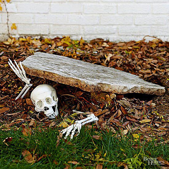 a fake human skull laying on the ground next to a wooden bench