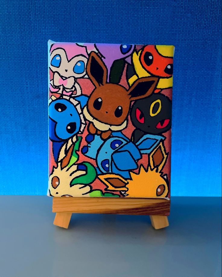 a small wooden easel with an image of pokemon characters painted on the front and sides