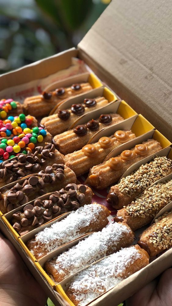 a box filled with lots of donuts covered in sprinkles and chocolate