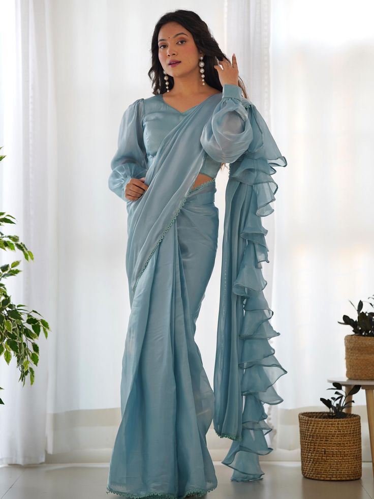 This exquisite saree is made from high-quality organza material in a beautiful blue color, featuring ruffle details and fancy lace border work that adds a touch of sophistication to your outfit. The saree comes in a 5.50 meters length, ready-to-wear, and includes a fully stitched blouse material, available in sizes XS to XXL for your convenience.
This saree include its trendy lace work that creates a fashion statement, making it perfect for parties, receptions, or any special occasion where you Saree Ruffle, Ruffle Sarees, Jacquard Blouse, Ruffle Saree, Readymade Saree, Ready To Wear Saree, Party Kleidung, Readymade Blouse, Wear Saree